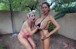 Big titted older women Claudia Marie and Minka kiss outdoors in skimpy bikinis on girlsfollowers.com